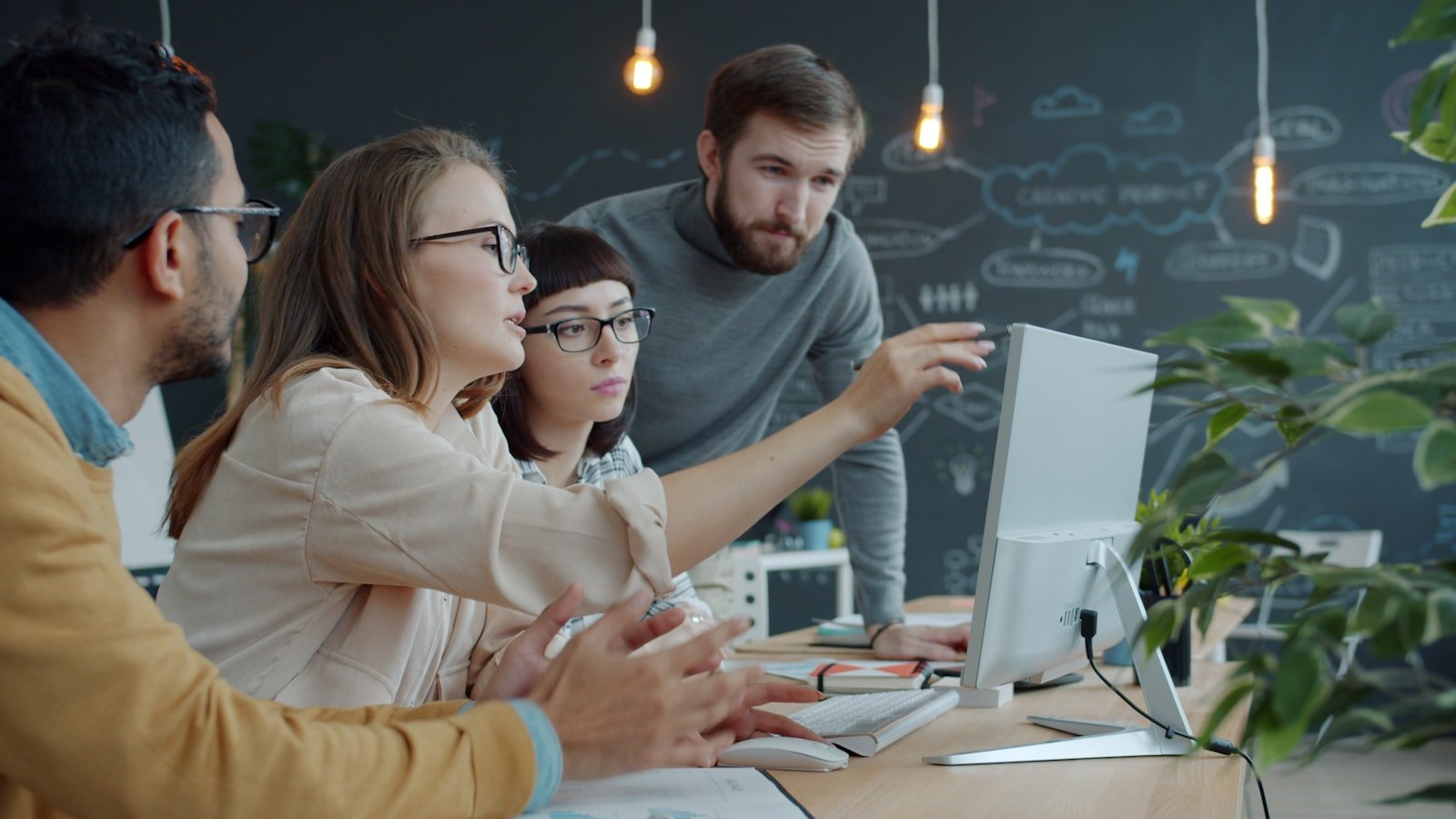 A team collaborating around a laptop in an office